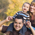 Happy Mixed Race Ethnic Family Posing for A Portrait in the Park.